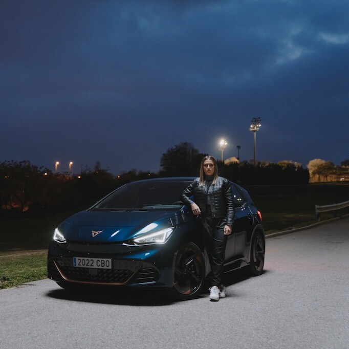 Alexia Putellas leaning on a CUPRA Born in Aurora Blue colour