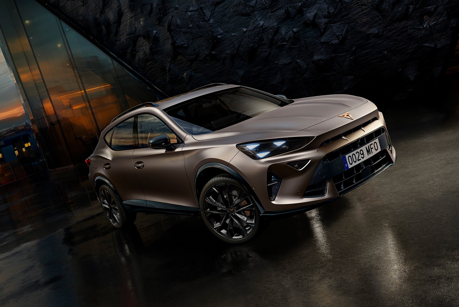 side view of the CUPRA Formentor 2025 in the colour Enceladus Grey matt, parked in an outdoors environment showcasing the car’s charging point.  
