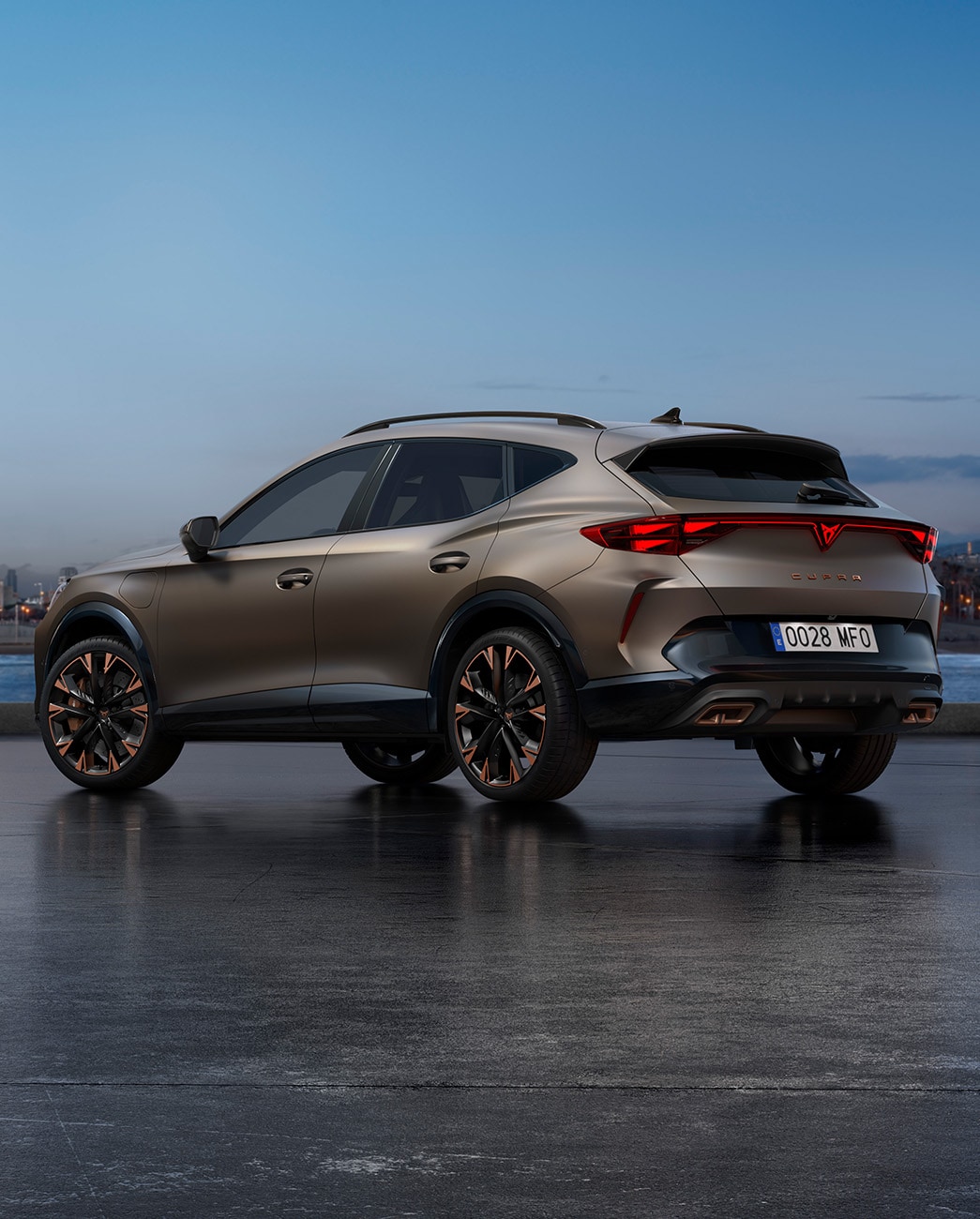 A new CUPRA Formentor 2025 century bronze matt CUV parked on a waterfront promenade during twilight. The background features a cityscape with skyscrapers and palm trees illuminated by the fading light of the day.