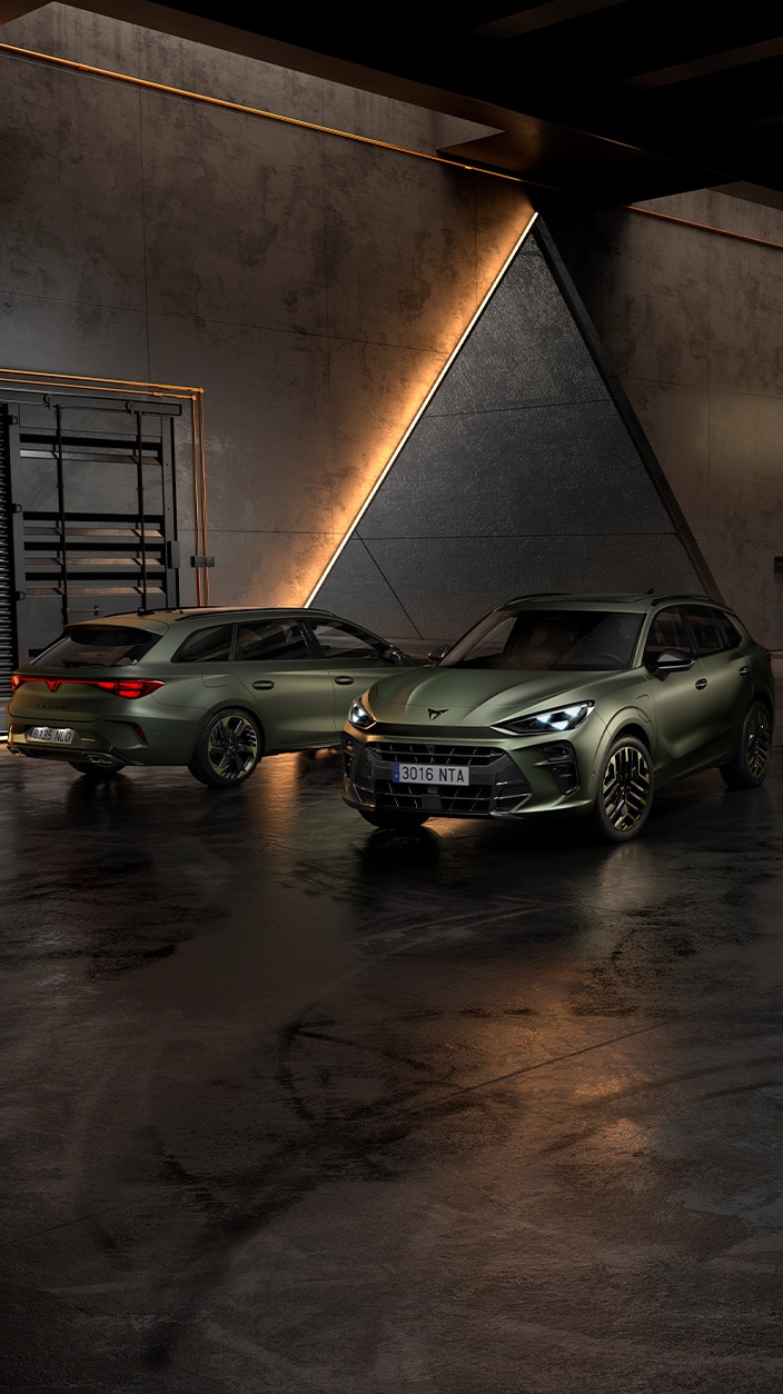 A close-up, eye-level shot shows the Cupra Formentor VZ5 and the Cupra Leon Sportstourer VZ5, parked inside a modern industrial garage.